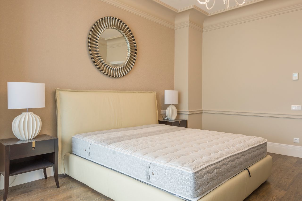services-04 Spacious bedroom featuring modern decor, elegant lighting, and a plush bed with neutral tones.